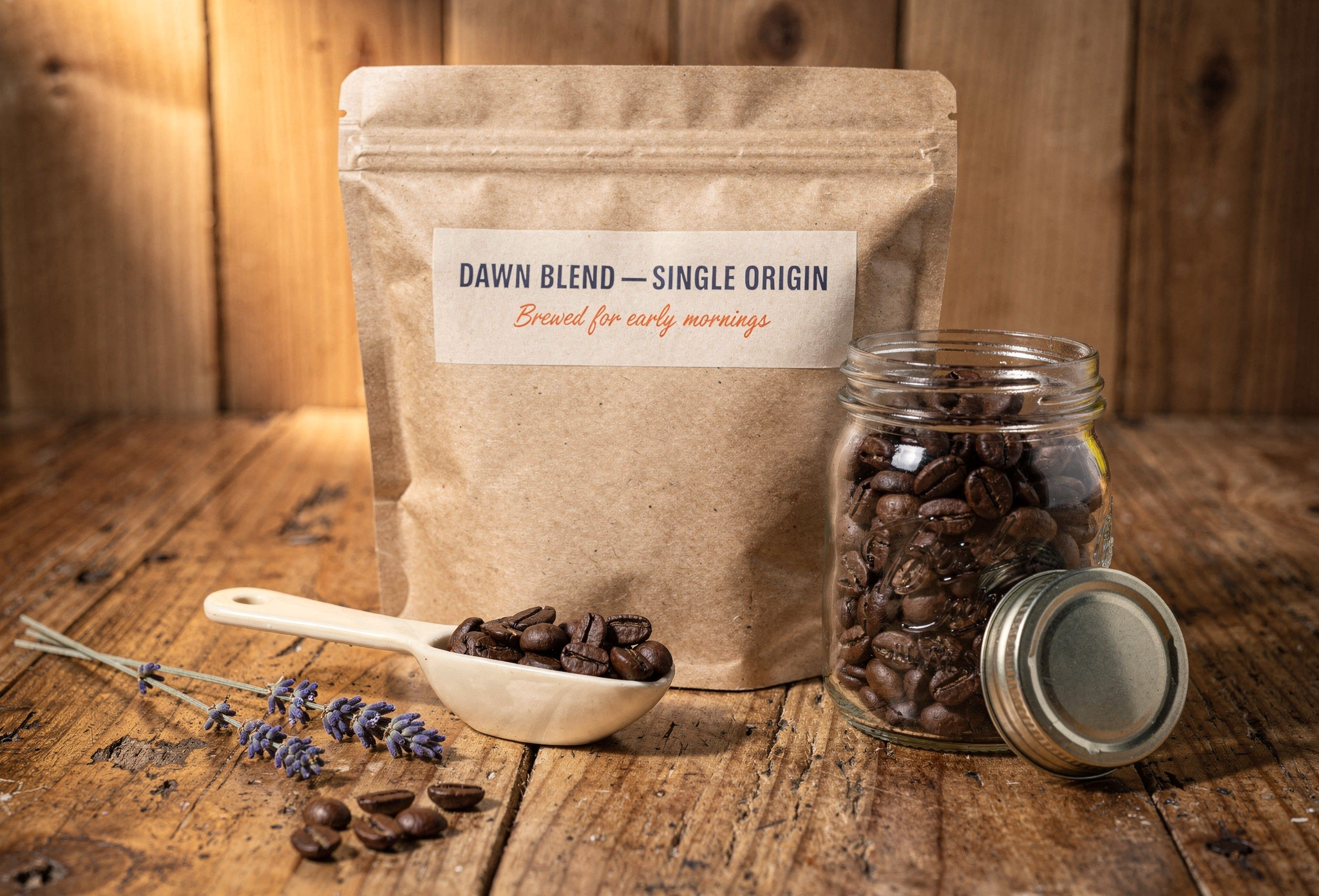 Ahşap tezgah üstünde sandy brown kraft kahve paketi yanında çekirdekler ve cam kavanoz